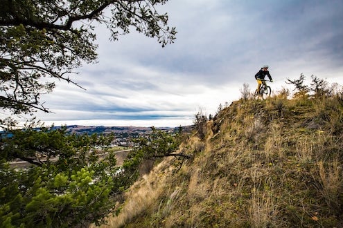 person mountain biking on trails