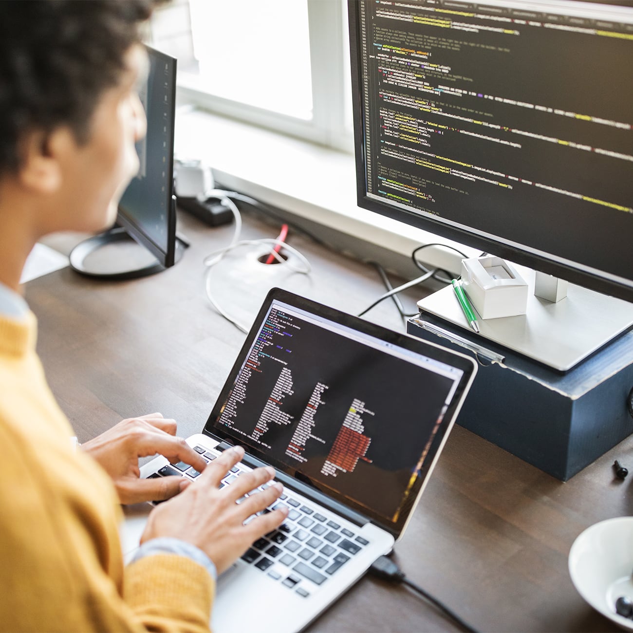 Man working on laptop with second display